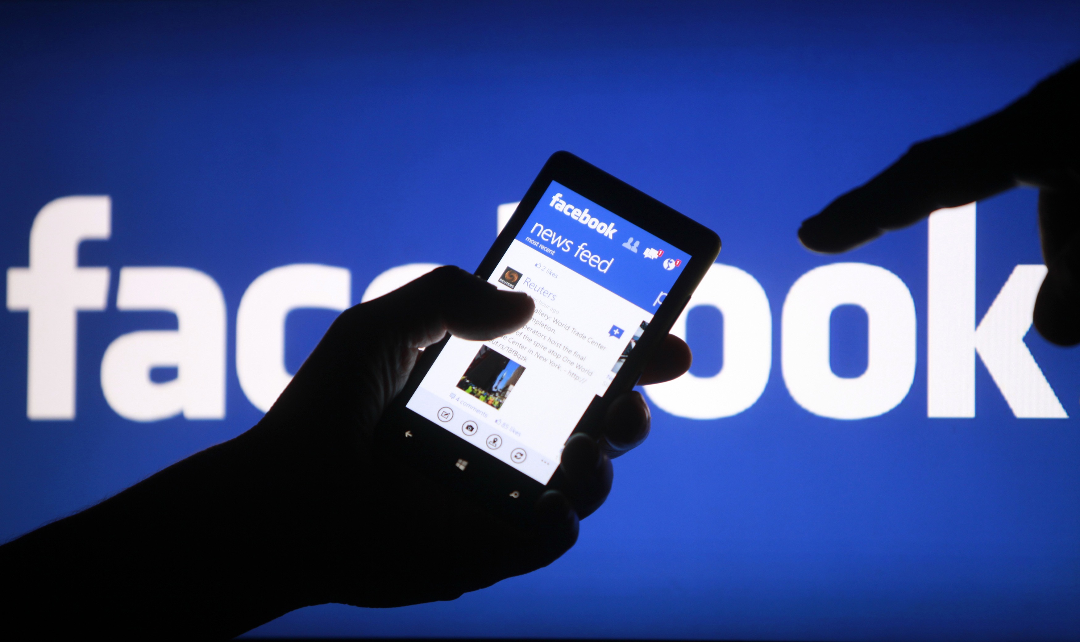 A smartphone user shows the Facebook application on his phone in the central Bosnian town of Zenica, in this photo illustration, May 2, 2013. Facebook Inc said July 24, 2013 that revenue in the second quarter was $1.813 billion, compared to $1.184 billion in the year ago period. REUTERS/Dado Ruvic /Files (BOSNIA AND HERZEGOVINA - Tags: SOCIETY SCIENCE TECHNOLOGY BUSINESS)